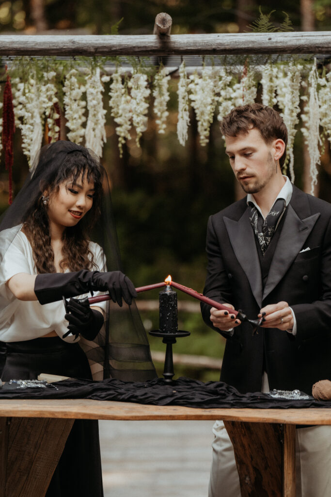 Gothic bride and groom lighting a ceremony candle at mt. rainier wedding venue